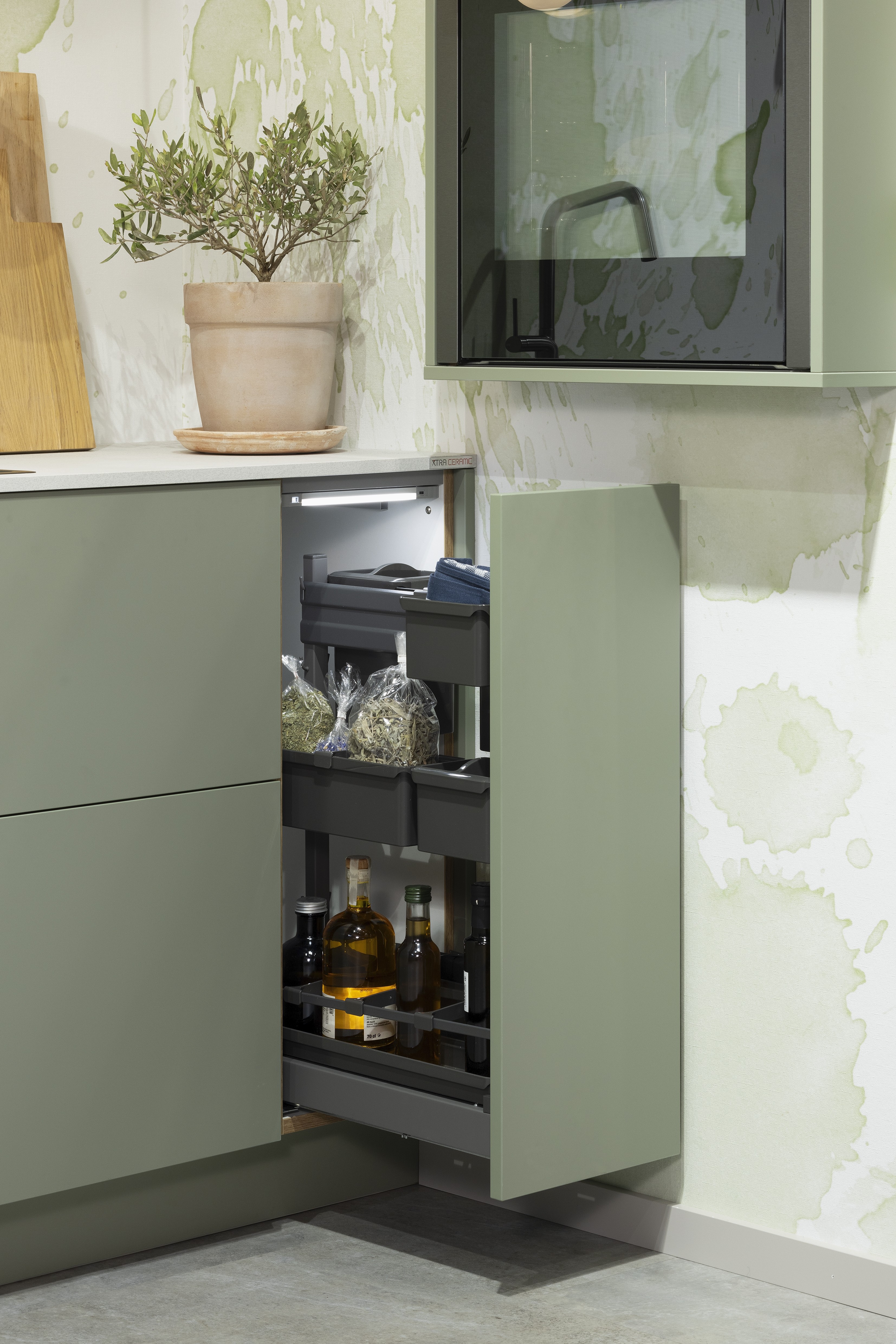 APL: 794 Beton Seidengrau NB (Xtra Ceramic) Korpus: 198 Eiche Sierra Front: Senso 495 Lack, Olive Premium matt Geräte: Neff Slide&Hide Armatur: Gessi  Spüle: Teka  Features: Trendfarbe Olive, Push to open, Tapete, neuer Schubkasten, Wandeinbau Backofen, beleuchtete Regale, beleuchtete Vitrinen, Weinflaschenregal, Schubkästen und Korpus in Eiche Sierra, Premium matte Oberfläche mit Antifingerprint, Nischenrückwand in Rillenoptik.